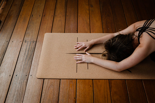 Yogi in forward fold on cork yoga mat
